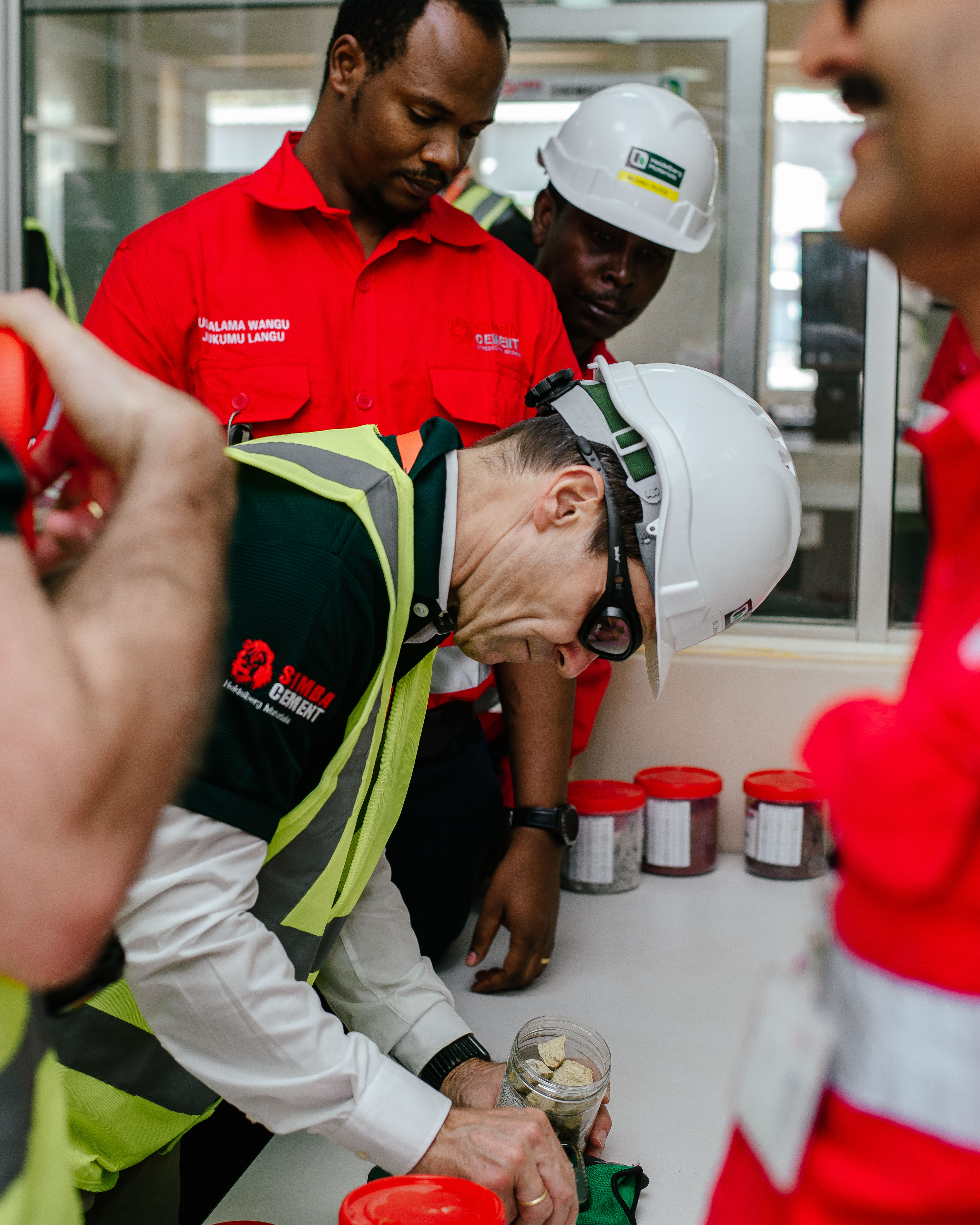 A group of construction professionals in safety gear examining materials on a table.